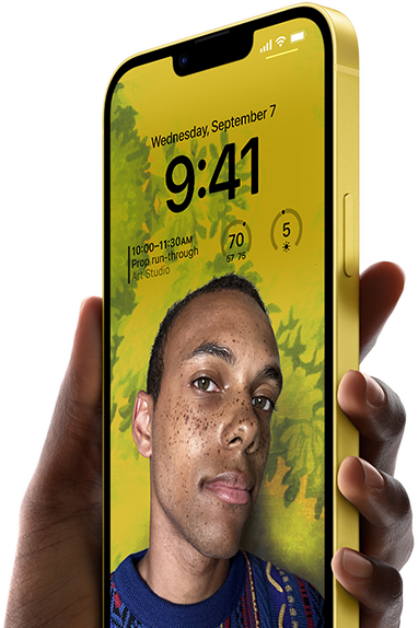 En hånd holder en iPhone 14 Plus i gul, der viser en personligt tilpasset låseskærm.