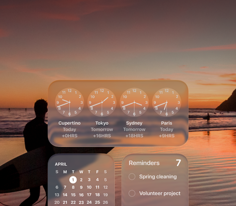 Liquid Glass-versioner af Ur-, Kalender-, Påmindelser- og Vejr-widgets på macOS Tahoe-skærm oven på en scene med en surfer, der går på stranden ved solnedgang