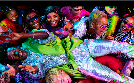 Farverig skærm på en MacBook Pro med en person, der crowdsurfer til en fest, hvilket demonstrerer den levende Liquid Retina XDR-skærm