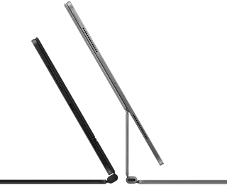 To iPad Pro-enheter er festet til Magic Keyboard. Den ene er i fargen stellarsvart og vises fra siden for å fremheve den tynne profilen, høyttalerne og USB-C-porten på siden. Tastaturdekselet er halvåpent. Den andre enheten er i fargen sølv, med åpent tastaturdeksel skrådd bakover for å vise den selvbærende designen, høyttalerne og mikrofonen.