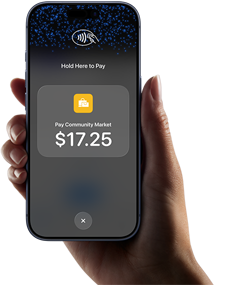 En persons højre hånd holder en iPhone, hvor skærmen viser et bestemt beløb, der skal betales, samt instruktioner til at foretage kontaktløs betaling, når brugeren er klar