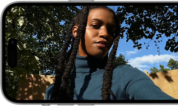 En iPhone 14 Pro i horisontellt läge med en skarp och färgstark selfie på skärmen.