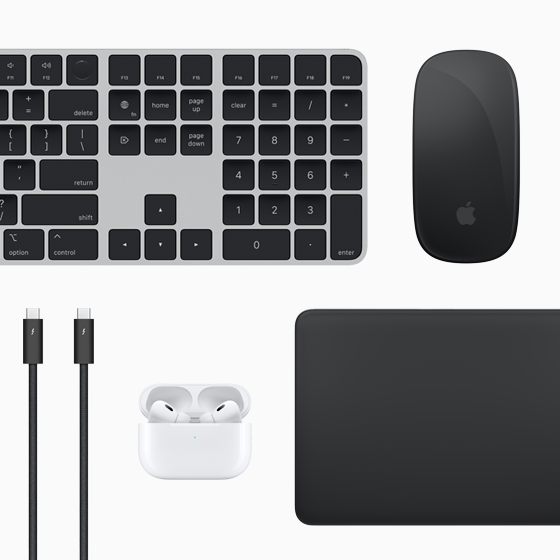 Mac-tilbehør set oppefra: Magic Keyboard, Magic Mouse, Magic Trackpad, AirPods og Thunderbolt-kabler