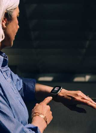 Henkilö lukee kohonneen verenpaineen ilmoituksen Apple Watch Series 11:stä