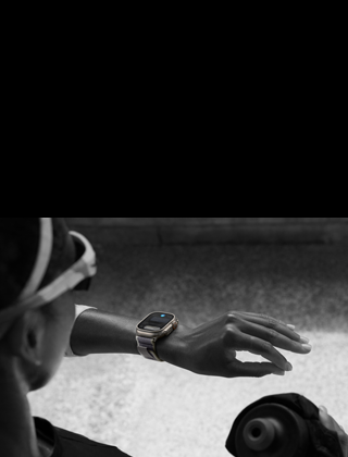 En joggare tittar på sin Apple Watch Ultra 2 på vänster handled och gör dubbeltouch-gesten med vänster tumme och pekfinger
