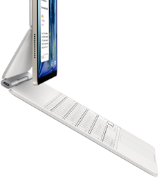 En iPad Air i fargen stjerneskinn festet til et Magic Keyboard i fargen hvit vises fra siden. 