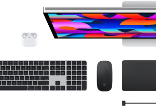 Mac-tillbehören Studio Display, AirPods, Magic Keyboard, Magic Mouse och Magic Trackpad sedda ovanifrån
